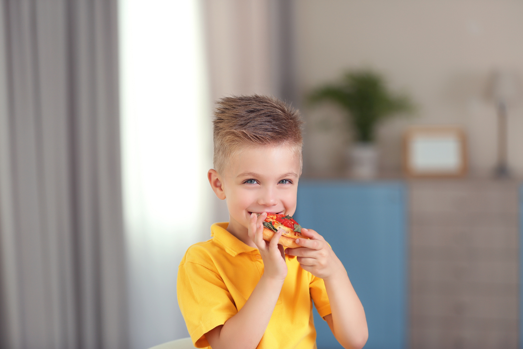 Boy Eating Pizza Indoors