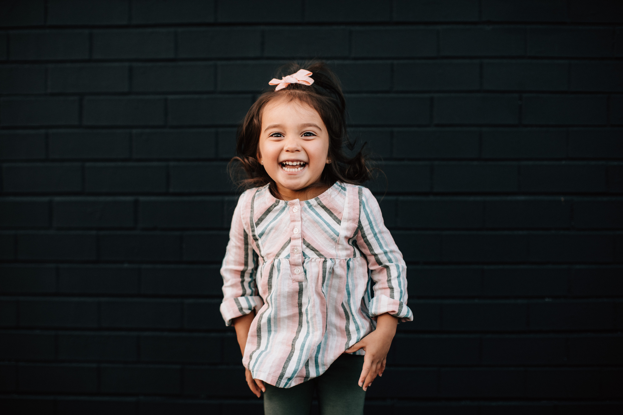 Portrait of Smiling Little Girl against the Black Wall